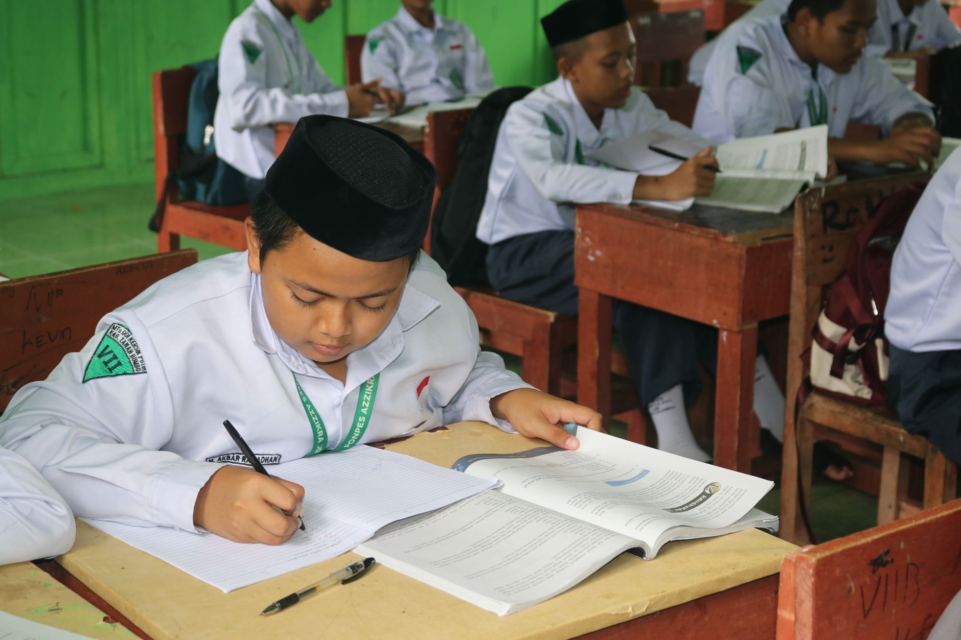 Anak-anak belajar bersama guru di kelas modern dengan papan tulis digital dan buku terbuka