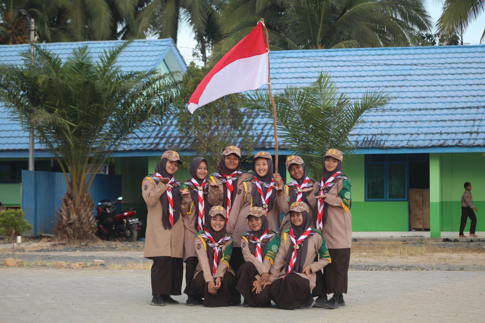 Gambar bendera Indonesia berkibar di depan gedung pemerintahan, melambangkan kebanggaan nasional
